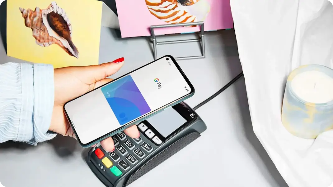 Person holding phone up to contactless payment system